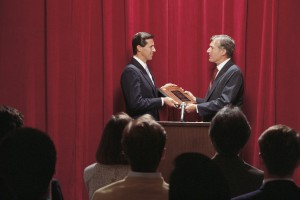 Businessmen accepting award on stage