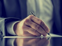 Man signing a document or writing correspondence